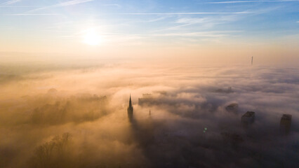 Aerial drone view of Tarnow townscape in dense fog at sunset. Poland.