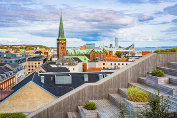 Weitblick von einer Dachterrasse auf die Dächer, den Dom und Gebäude von Aarhus, blauer Himmel, leicht bewölkt, horizontal