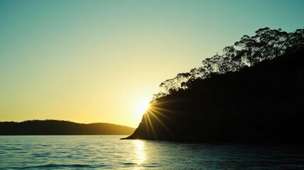 Sunset over water with silhouetted trees and land