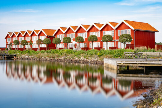 Rote H&auml;user am Hafen von Ebeltoft, die sich im Wasser spiegeln, horizontal, Langzeitbelichtung