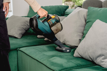 The process of cleaning a sofa with a vacuum cleaner with a special nozzle