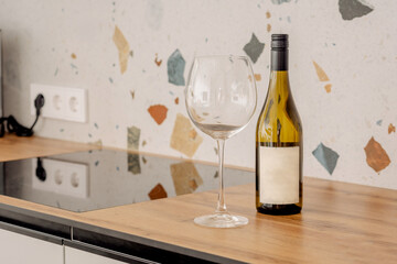 A bottle of white dry wine next to a glass