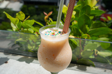 Fruit smoothie with sprinkles and straw 