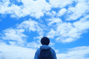 Person looking at blue sky with fluffy clouds