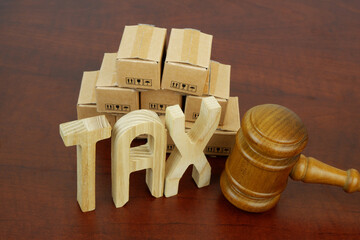 Taxes concept. Letters tax, many carton boxes and wooden gavel.