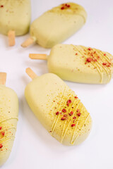 pistachio-raspberry cheese dessert  in a popsicle shape isolated on the white background