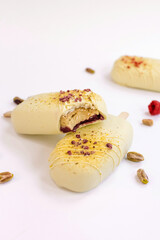 pistachio-raspberry cheese dessert  in a popsicle shape and flower and pistachio topping  cut in half