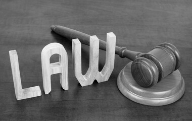 Close up of judge gavel and word LAW on table. Law and legal system concept.