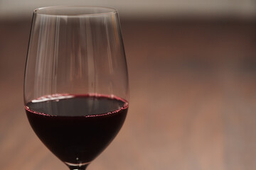 Red wine in thin wine glass on wood table