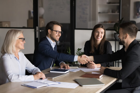Two business parties shaking hands greeting each other start negotiations in board room, express mutual respect, thanking for cooperation, successful teamwork, establish partnership in company office