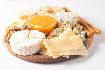 Wooden board with various cheese and olives. Brie. Camembert. Parmesan, feta, blue cheese. Italian, French cheese.