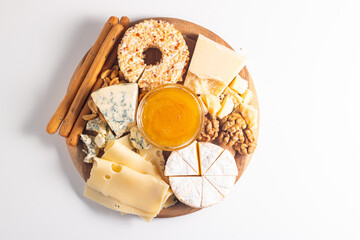 Wooden board with various cheese and olives. Brie. Camembert. Parmesan, feta, blue cheese. Italian, French cheese.