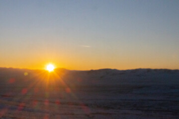 Beautiful sunset with sun rays with hills silhouette and copy space