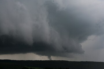 Gewitterwolken über bewaldeter Landschaft