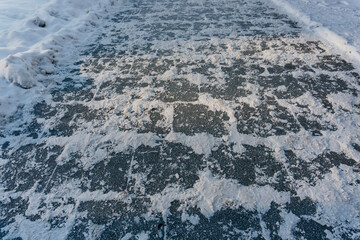 Naklejka premium a sidewalk covered with snow in Kazakhstan. pedestrian sidewalk full of snow in Shymkent