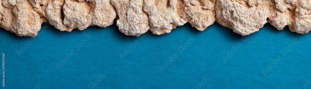 Poster textural contrast: beige stones arranged in a row against a vibrant teal background, creating a visu