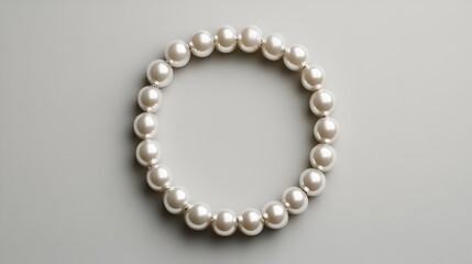 Obraz premium Flawless pearl necklace arranged neatly in a circular shape lying on a pale grey background showcasing the simplicity and luxury of the design in a minimalist style