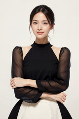 A woman is wearing a black dress with a white skirt. She has a beautiful smile and is posing for a photo