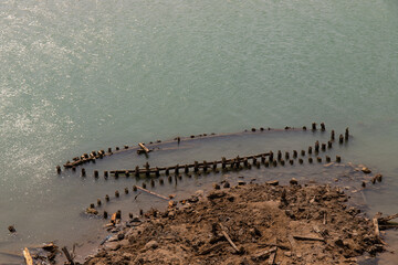 Remains of the hull of wooden ships by the sea.