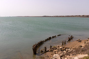 Remains of the hull of wooden ships by the sea.