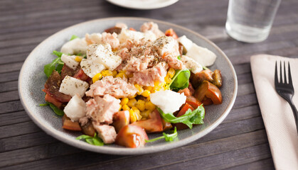 Plate of salad with tuna, corn, tomatoes and arugula
