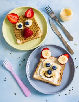 Naklejki Funny animal faces toast with peanut butter, banana, strawberries and blueberries for kids breakfast