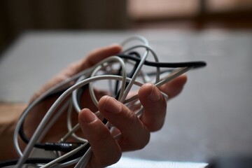Tangled Cords in Hand The Everyday Clutter and Chaos of Our Modern Technology Life