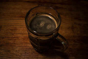 mug of beer stands on a wooden surface