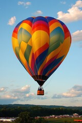 Obraz premium Solo hot air balloon flight soaring over breathtaking landscapes during golden hour in the vast wilderness