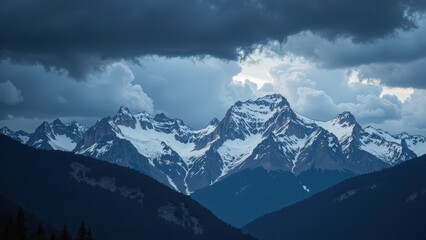 Obraz premium Snow-capped peaks dominate the serene expanse of a majestic mountain range under a radiant, deep-blue sky, basking in sunlight's embrace