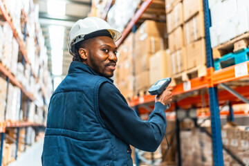 Happy african worker scanning packages in a large warehouse