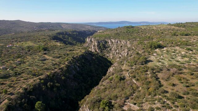 Beautiful aerial drone shot of a valley on the Brac island in Croatia, between the towns of Sutivan, Milan and Supetar. Shot taken during the olive harvest season and traditional olive oil production.