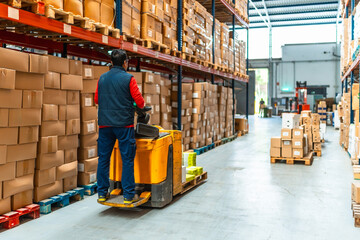 Man driving hydraulic hand truck in a distribution warehouse