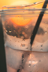 Water drops condense on a plastic glass of cold drink

