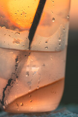 Water drops condense on a plastic glass of cold drink
