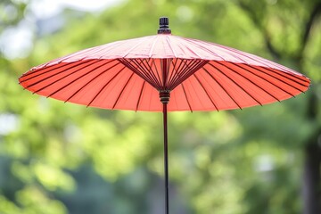 Bright Red Umbrella with Decorative Design Against a Soft Green Background in a Relaxing Outdoor Setting
