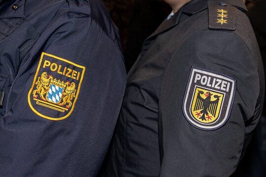 Zwei Uniformen von Polizeibeamten im Detail: Links die Uniform der Bayerischen Polizei mit dem Wappen Bayerns auf dem &Auml;rmel, rechts die Uniform der Bundespolizei mit dem Bundesadler-Emblem.