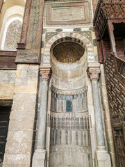 Interior of Sultan Qalawun Mosque with stone columns, colored stained glass windows and wooden doors, Cairo, Egypt