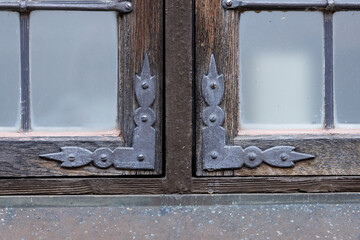 Decorative metal corner frame fastenings on a grated window in the wall of a building in Frederiksborg Castle