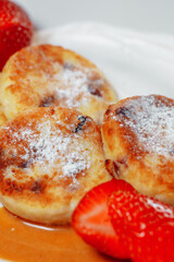 Sweet delicious food for breakfast. Pancake cheesecakes with fresh strawberry, blueberry and maple syrup. Delicious tasty pancake, morning food in cafe. 