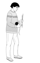 African American man stands with knitting needles and balls of thread in his hands