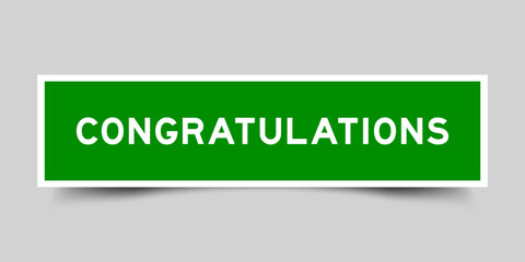 Green color square shape sticker label with word congratulations on gray background