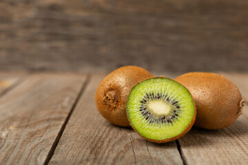 Kiwi on wooden background. Whole fruit and slices pieces of green kiwi on table. fresh ripe juicy...