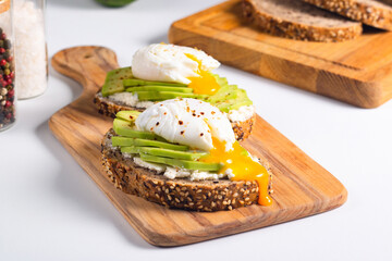 Two avocado open sandwiches with egg. Keto and diet concept. Healthy toast food for breakfast.