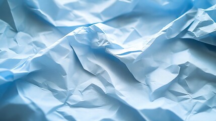 Obraz premium Crumpled blue paper texture close-up creating an abstract design with waves and folds