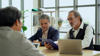 serious senior business manager man talking or debate to colleagues in meeting on table with data...