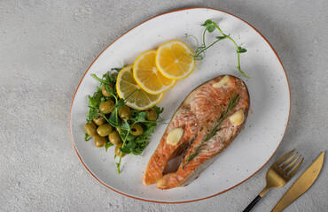 Baked trout steak with lemon, rosemary and garlic