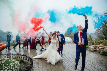 A bride and groom are surrounded by their wedding party, with the bride wearing a white dress and...