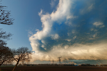 Dramatic cloud formation over a rural landscape at sunset showcasing nature's changing moods