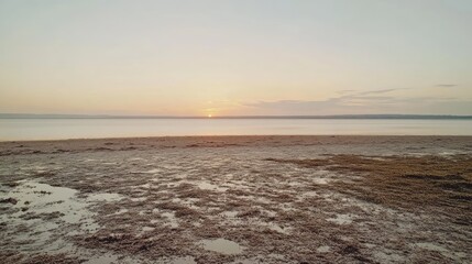 Obraz premium Sunset over calm lake, mudflats foreground, peaceful evening scene, travel photography